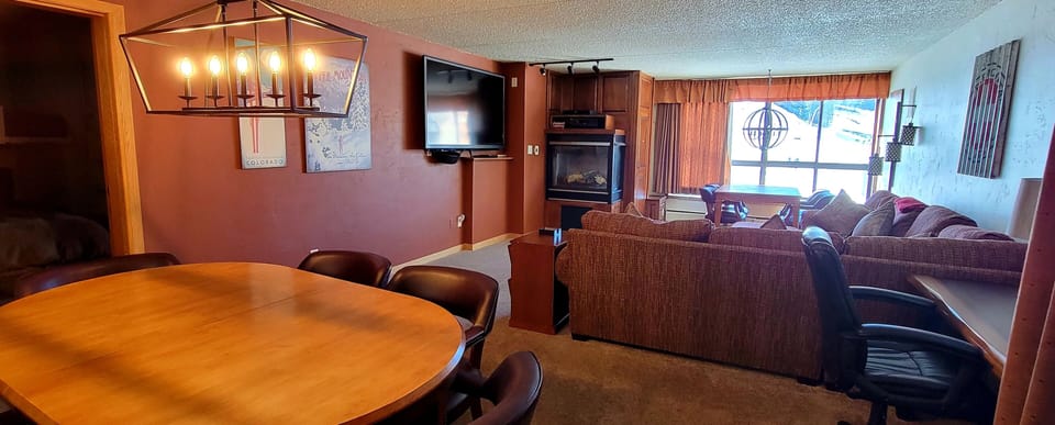 Dining and living area with a desk and gas fireplace. 
