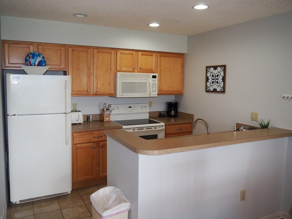 KITCHEN:  The condo has a convenient and efficient full kitchen with all appliances including a dishwasher.  A good collection of cooking and dining utensils is also included with the rental.