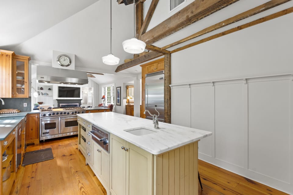 Main house kitchen with gas stove, three ovens, microwave, dishwasher