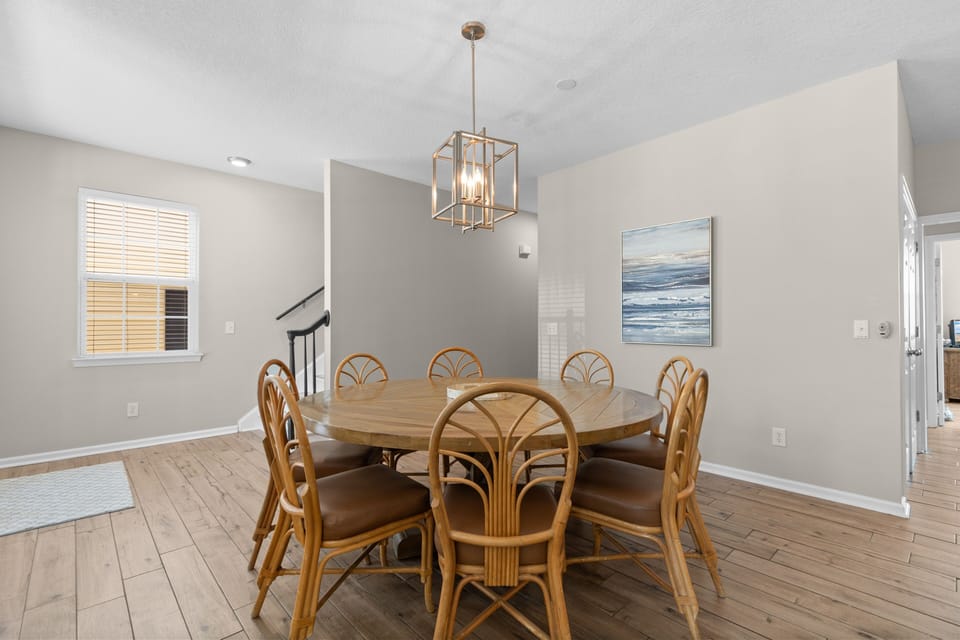 Gather around this inviting dining table for memorable meals. The coastal artwork and warm lighting create a welcoming atmosphere for your group to relax and enjoy togetherness.