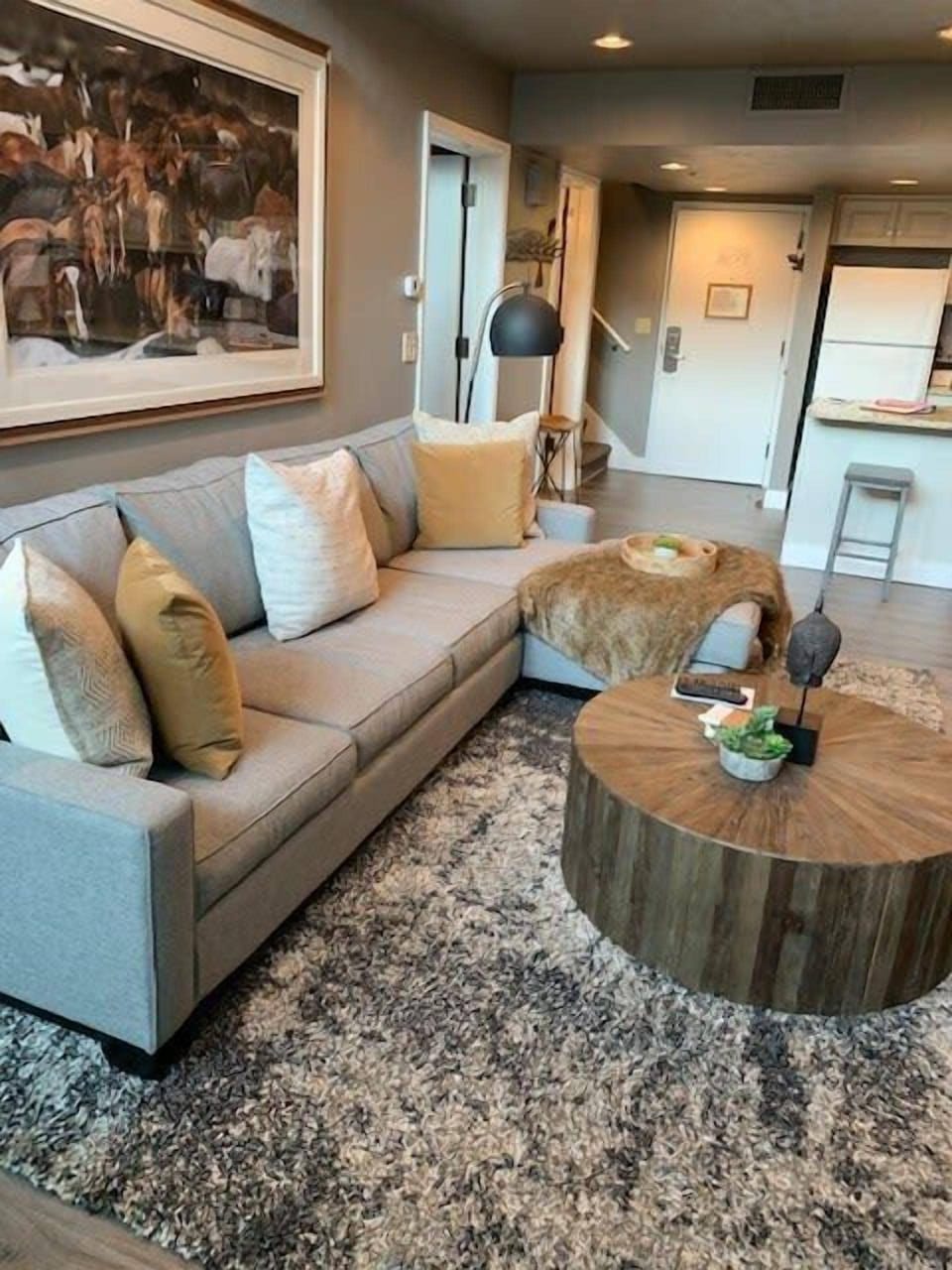 Family room with a comfortable sectional sofa, lounge seating, indoor gas fireplace, flat-screen TV, and lovely interior decor throughout the home