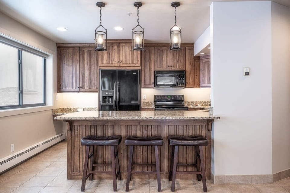 Spacious fully-equipped kitchen with granite countertop and bar stool seating