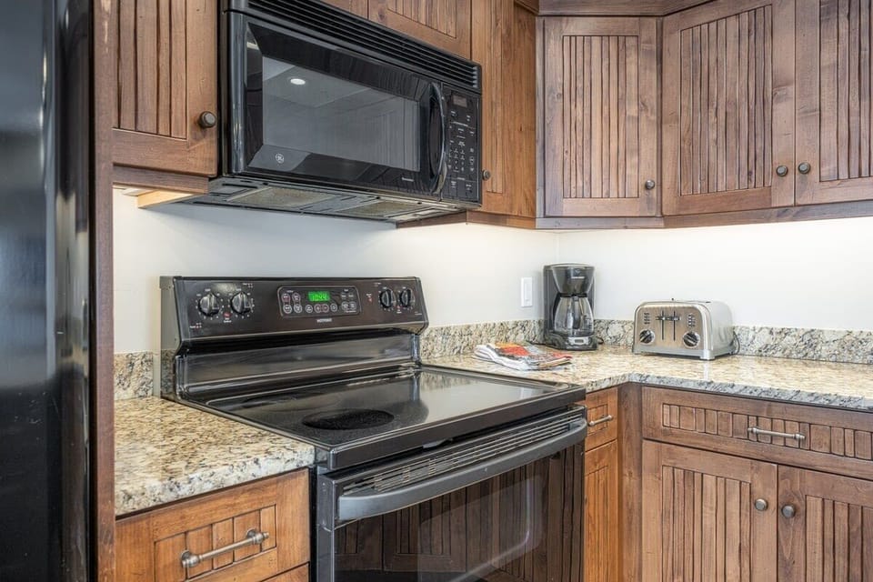Spacious fully-equipped kitchen with granite countertop and bar stool seating