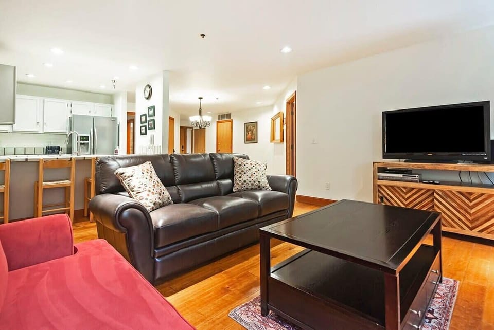 Relax in the family room with a leather sofa, a plush sofa, armchair seating, an indoor wood fireplace, and a flat-screen TV
