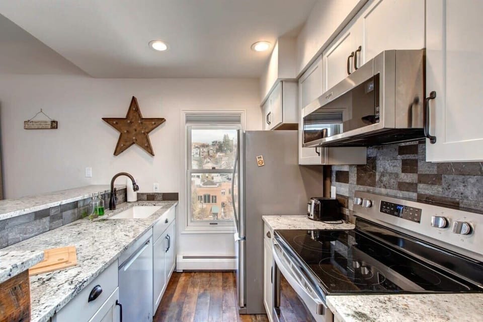 This bright and lovely kitchen features stainless steel appliances, ample storage space and views of historic Old Town. Its sophisticated finishes make it an inviting place for whipping up a favorite recipe.