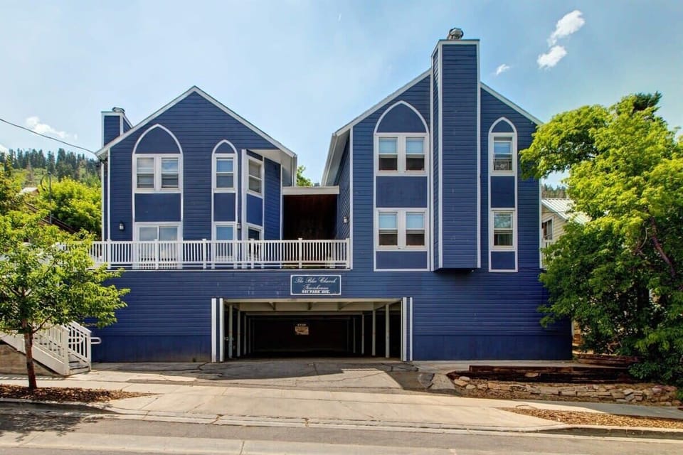 The exterior of the home in its recognizable colors of blue and white features an underground parking garage and is located just across the street from the Blue Church Lodge.