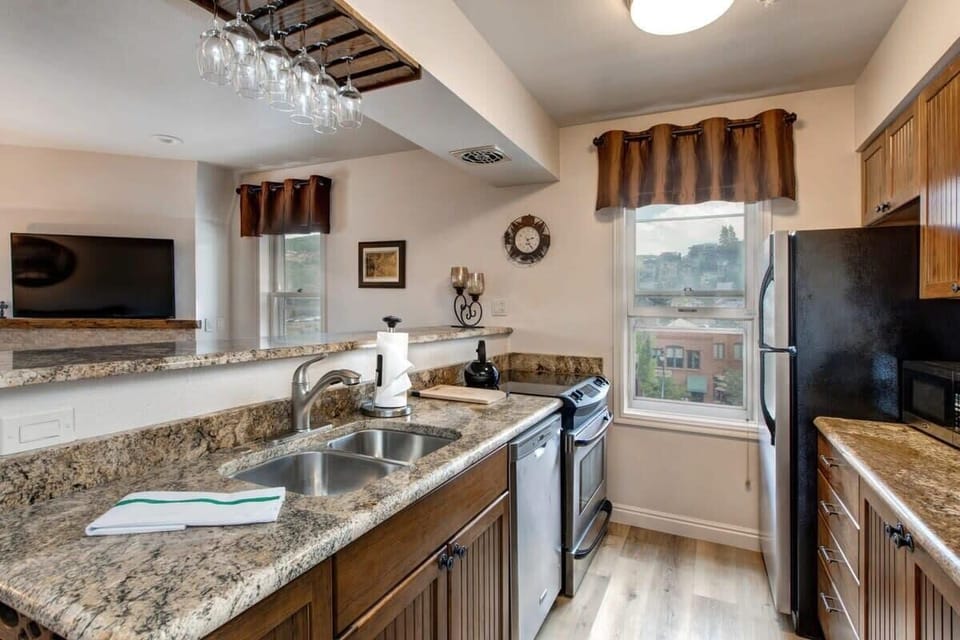 This lovely kitchen features stainless steel appliances, an eat-in bar/serving area with seating for three and fabulous views of history Old Town Park City.
