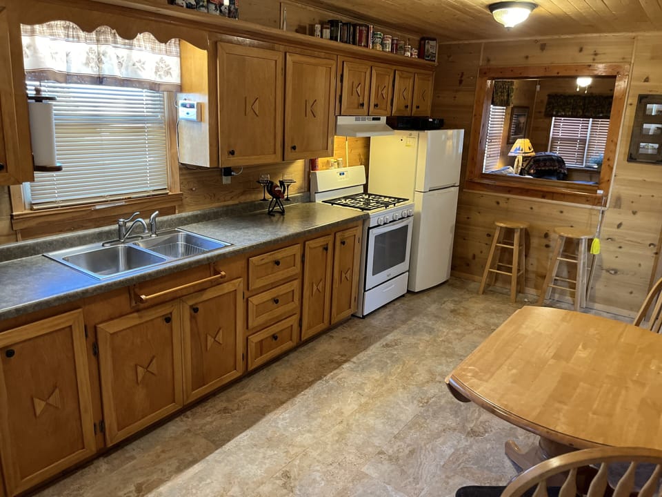 Full kitchen with coffee maker, microwave, blender, stove, toaster, and fridge. 