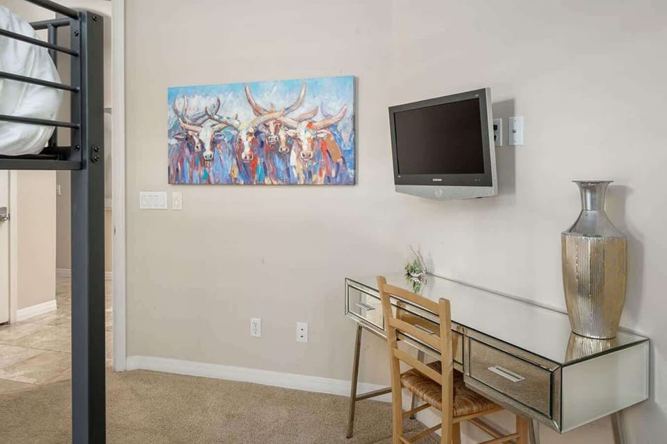 A small desk space and tv in room.