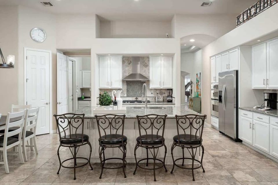 This lovely kitchen features a spacious sit up bar/kitchen island, great for preparing a meal or serving it.
