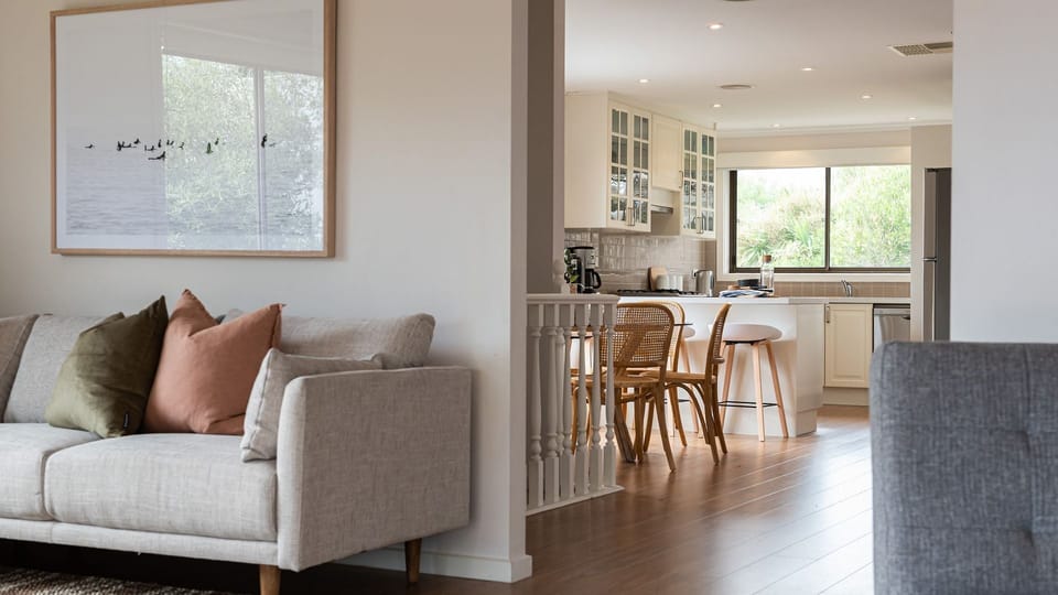 Comfy sofa with a peak of the kitchen and dining