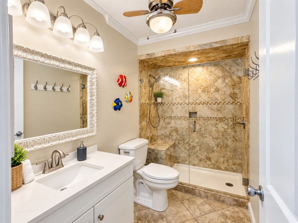 Bathroom adjacent to the master bedroom, featuring a spacious walk-in shower with glass doors, tiled walls, and a modern vanity.
