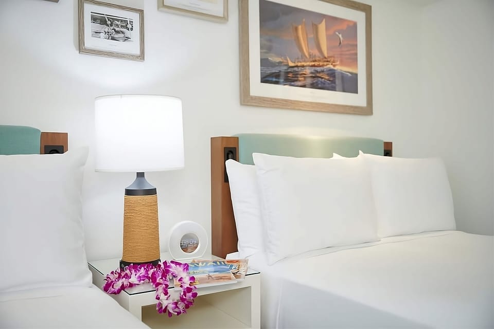 Recharge at bedtime with soft lamps and serene coastal art.