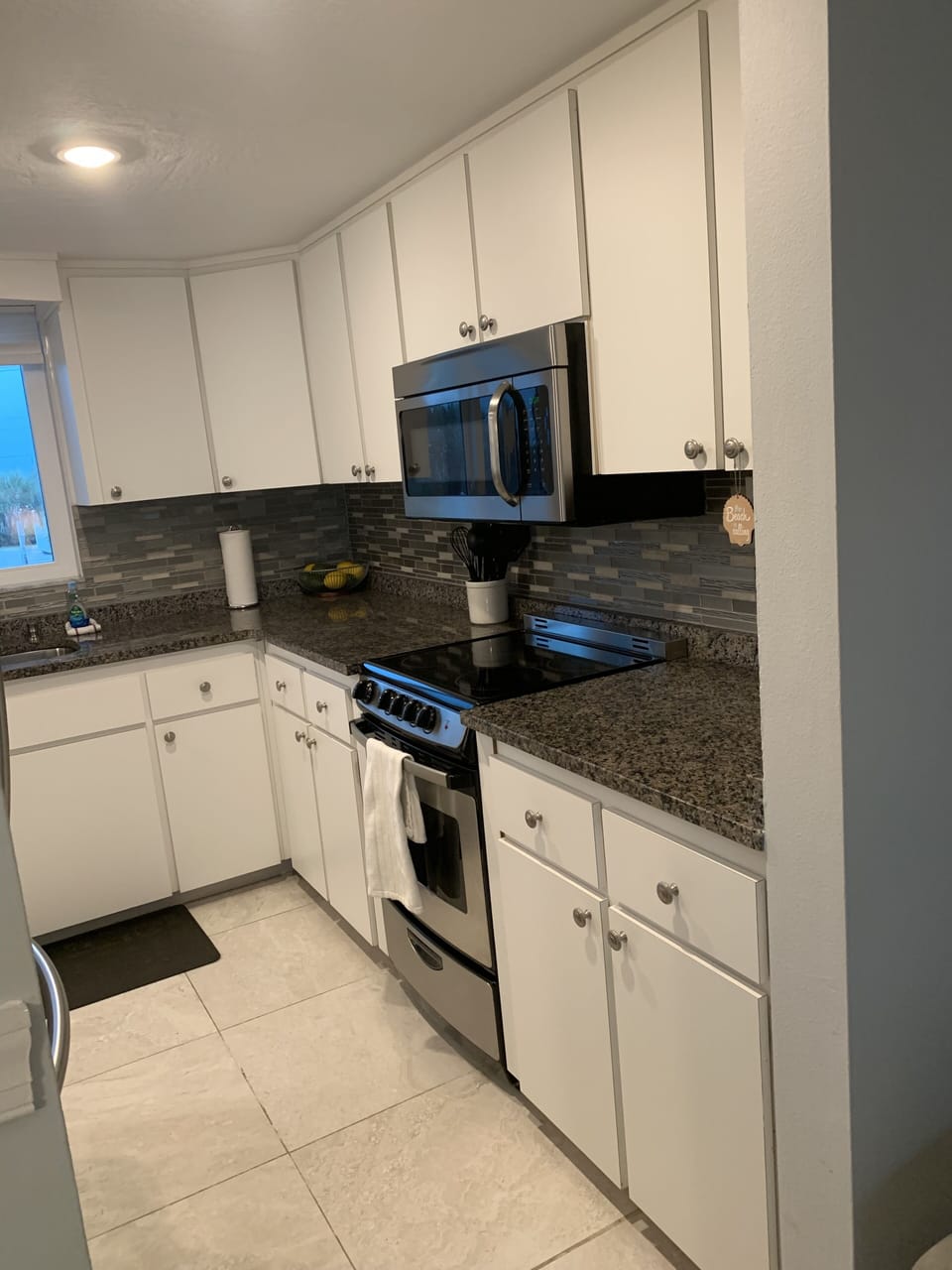 Full Kitchen with stove, microwave and stainless steel refrigerator