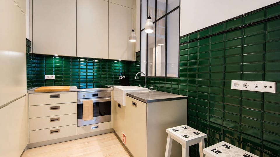 A sleek, fully equipped kitchen elevated by statement emerald-green tiles — ready for everything from morning coffee to dinner at home. #FullyEquippedKitchen #InteriorDesign #HomeAwayFromHome #LovelyStay