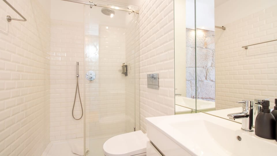 Refresh yourself in the sleek, modern bathroom featuring a spacious walk-in shower with gleaming subway tiles, offering a pristine and invigorating start or end to your day. The contemporary design ensures a comfortable and clean experience.