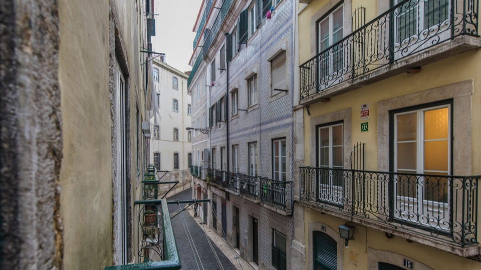 Experience the authentic pulse of Lisbon from your private balcony, offering captivating views of charming, tiled buildings and the bustling street below. Imagine enjoying your morning coffee while soaking in the vibrant city atmosphere.