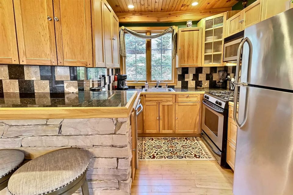 Kitchen area with refrigerator, microwave, stove, oven, sink, and dishwasher.