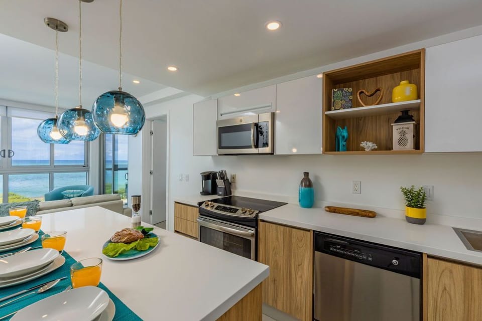 Picture yourself preparing meals in this bright, modern kitchen with ocean views just beyond. Enjoy your morning coffee at the sleek island while the sea breeze flows through the open windows.