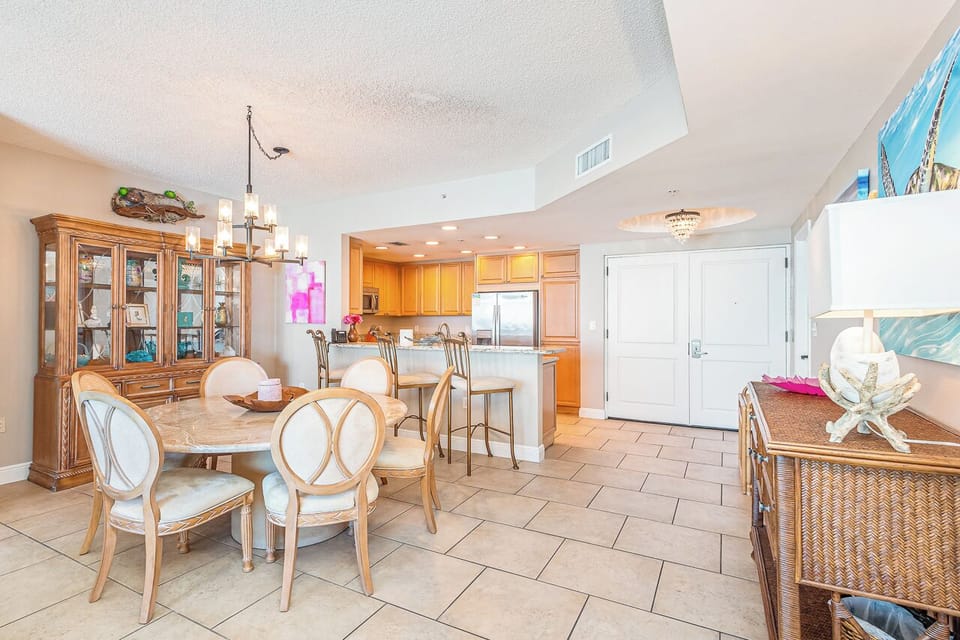 Gather around the spacious dining table where coastal charm meets comfort, with a fully equipped kitchen just steps away ready for your family feasts.