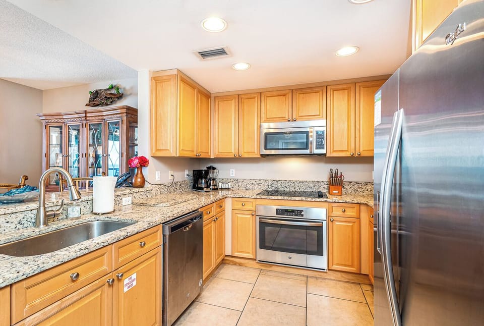 Picture yourself cooking in this bright, fully equipped kitchen with granite counters, stainless appliances, and rich wood cabinetry—everything you need to feel right at home during your stay.