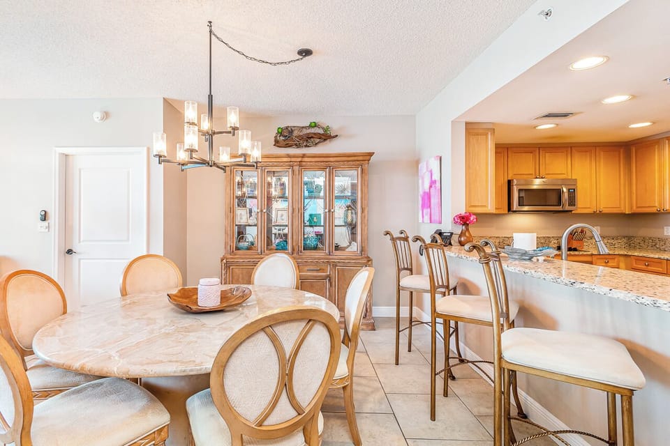 Gather around this elegant dining space, where your morning coffee or family meals feel extra special with warm lighting and thoughtfully arranged seating flowing into a fully equipped kitchen ready for your culinary adventures.