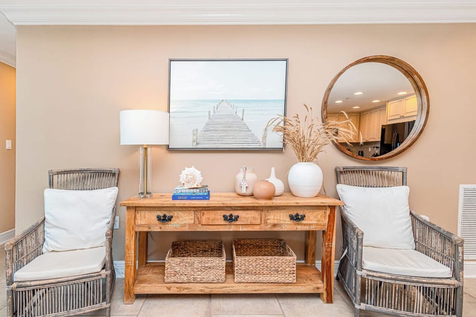 Unwind in this serene sitting area with coastal charm—cozy rattan chairs, warm wood accents, and soft lighting create your perfect relaxation spot.
