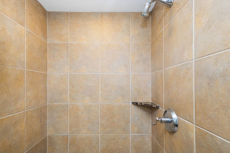 Step into your private tiled shower with modern fixtures and a sleek, easy-to-clean design for a refreshing start to your day.