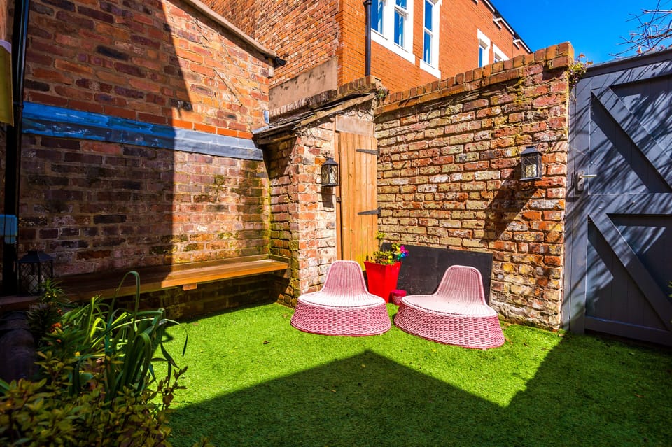 Private sunny back garden with seating and outside plugs