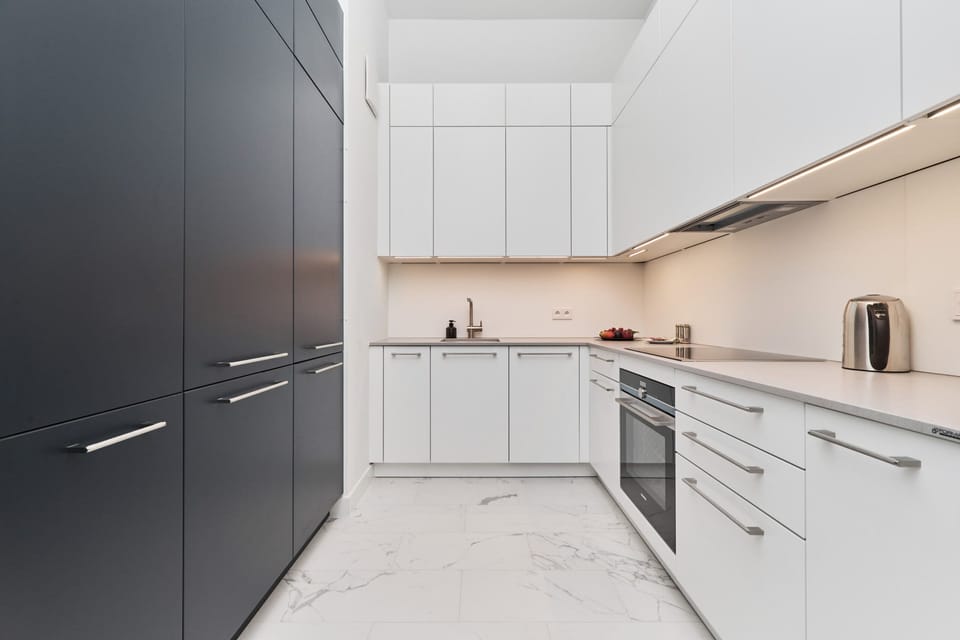 A compact kitchen with white cabinets, modern appliances, and a clean layout.
