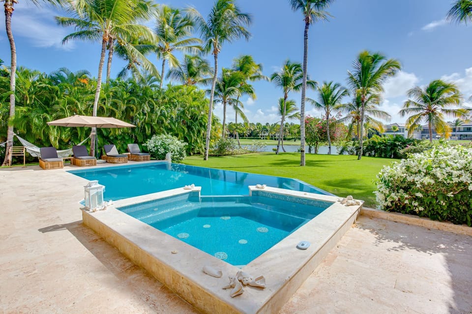 Pool area with hot tub, lake and golf views, outdoor living and a large garden
