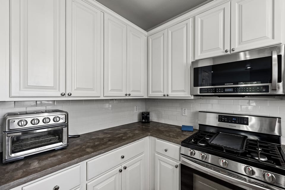 Kitchen appliances at Summer Bliss — stainless gas range, microwave, and ample counter space for cooking real meals during your Galveston stay.