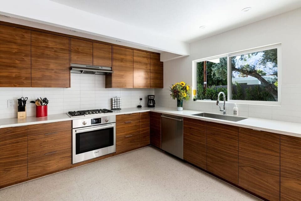 Where warmth meets sophistication – a full kitchen with rich wood cabinets and sleek white countertops for the perfect balance of style and function.