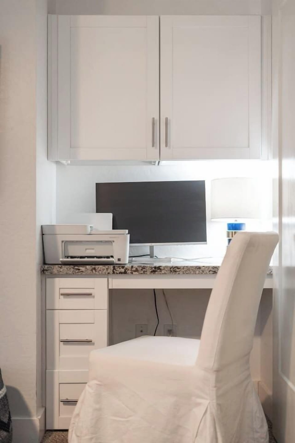 Efficient dedicated workspace with a monitor and printer, designed for productivity and organization.