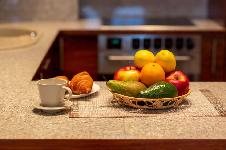 A close-up of a countertop with fresh fruit and coffee cups, adding a welcoming touch.