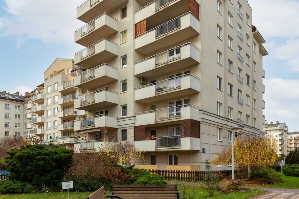 The exterior view of apartment building surrounded by greenery.