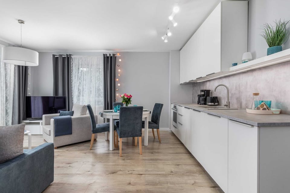  The spacious living area is combined with a kitchenette with white cabinets that hold all the necessary accessories.