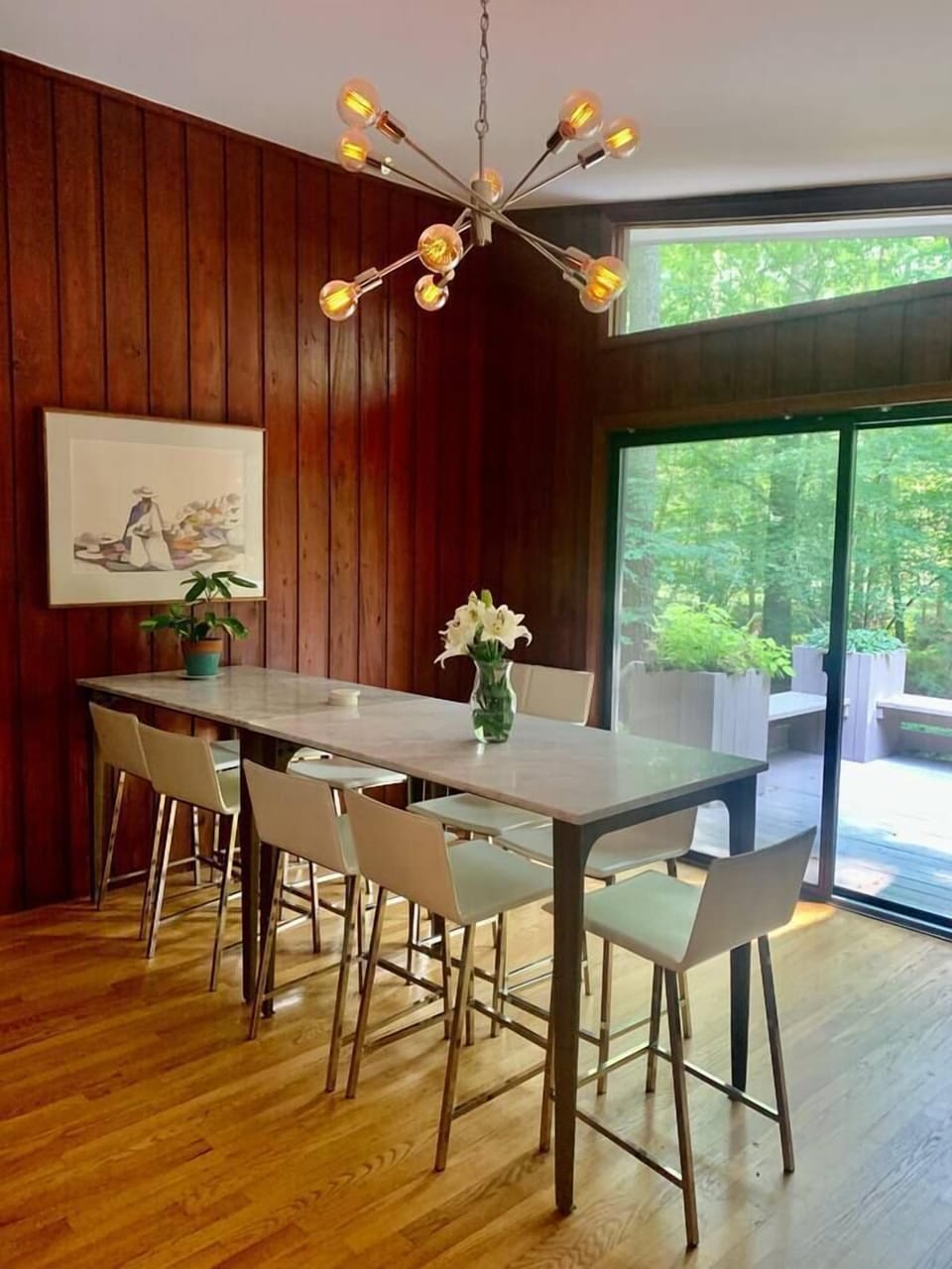 Cabin vibes meet mid-century modern meet formal yet playful luxury in this dining room. There's  seating for 9 at these CB2 marble high top dining tables with CB2 white leather chairs. Located between the kitchen and one of two entrances to the deck.