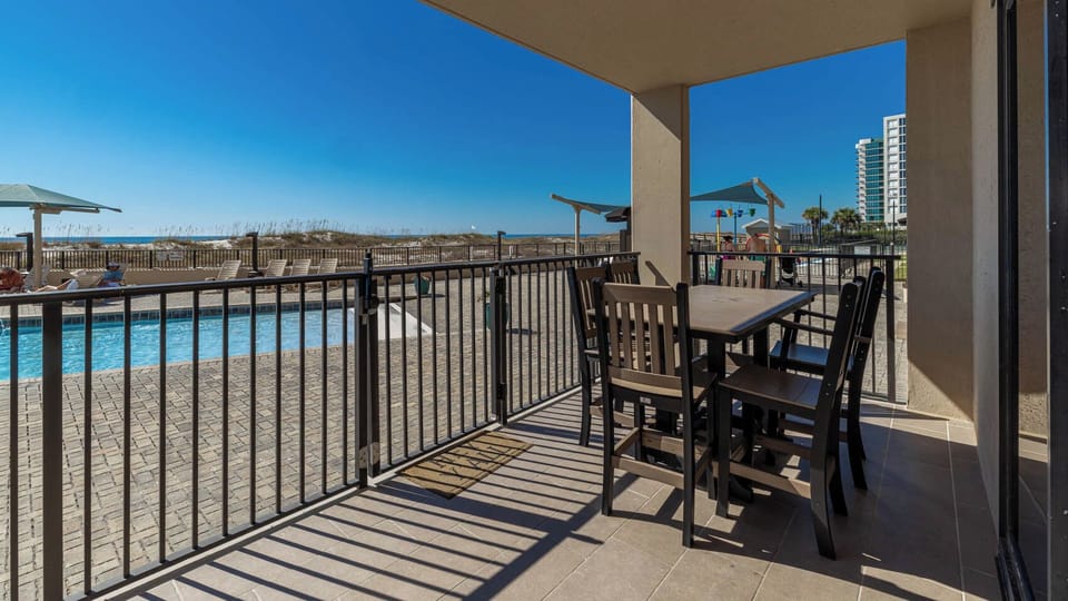 Relax at the outdoor dining set, overlooking the pool and enjoying the refreshing breeze from the beach