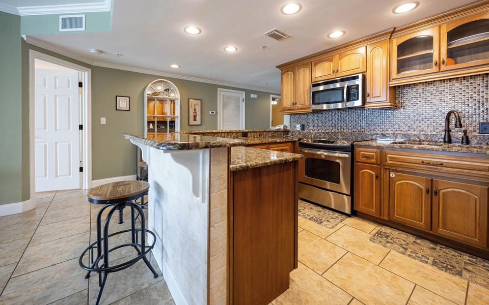 Sleek kitchen with bar seating, stainless appliances, and elegant cabinetry, perfect fo enjoying time together