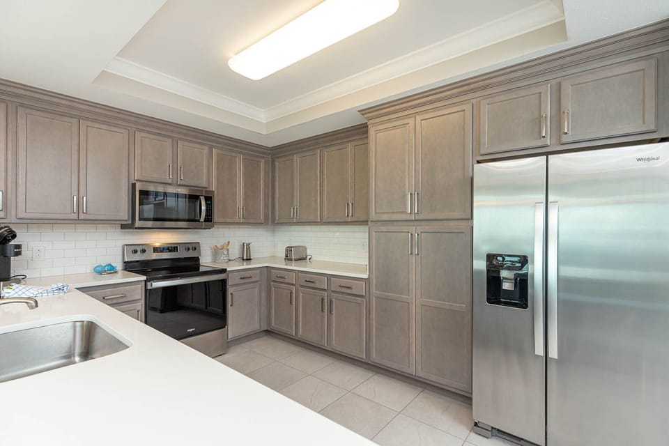 Prepare meals in this kitchen with elegant cabinetry, stainless appliances, and spacious countertops