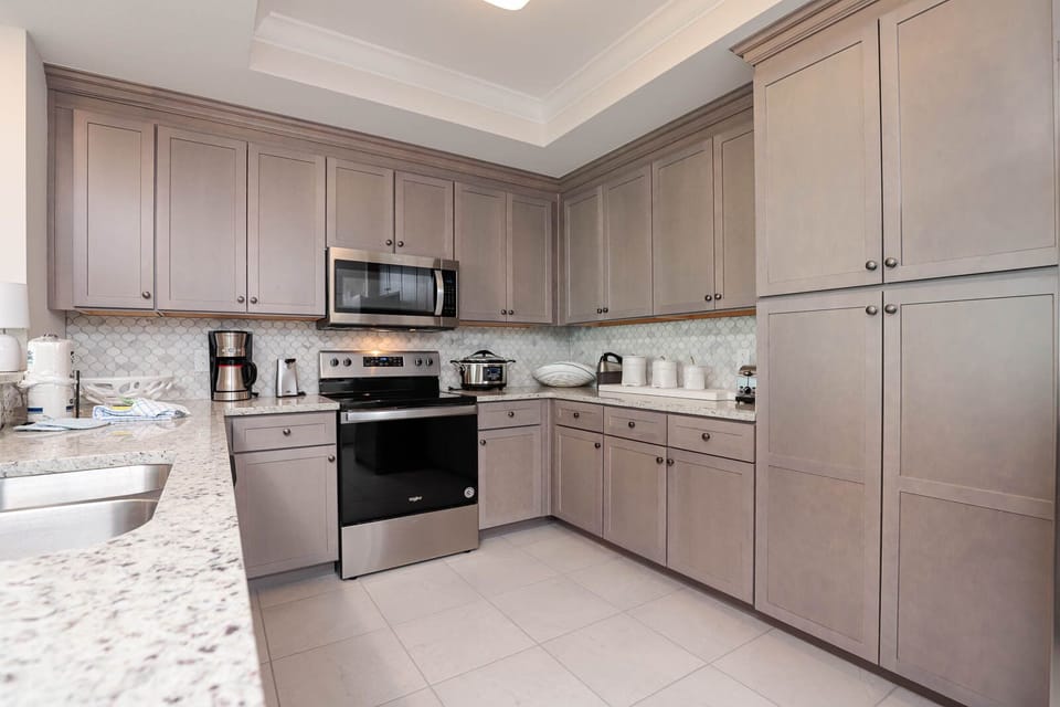 Prepare meals in this kitchen with elegant cabinetry, stainless appliances, and stylish backsplash