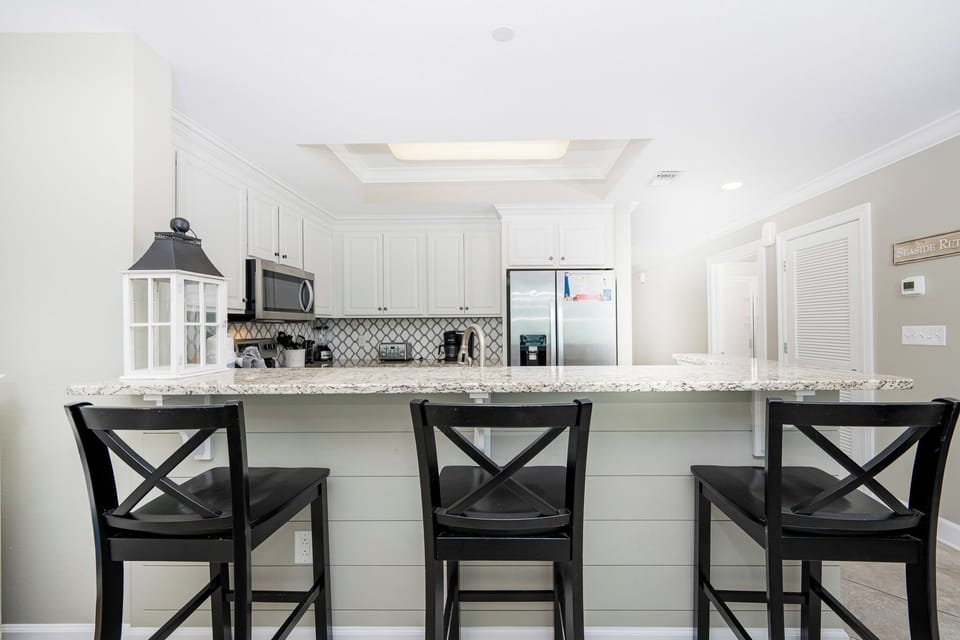 Gather around the wet bar with friends, mixing drinks and enjoying the casual vibe of your beachside retreat