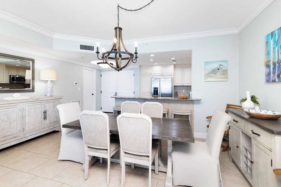 Gather around the farmhouse-style dining table under soft chandelier lighting. This open-concept space flows into your gourmet kitchen, creating the perfect setting for memorable meals together.