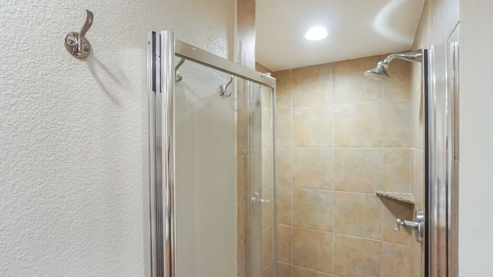 Step into your clean, modern walk-in shower featuring warm tile, a built-in bench for comfort, and a sleek glass enclosure that makes every morning feel like a spa experience.