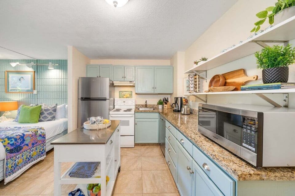 Modern galley kitchen with ample granite counter space, stainless steel appliances, and a mobile island for extra prep room.