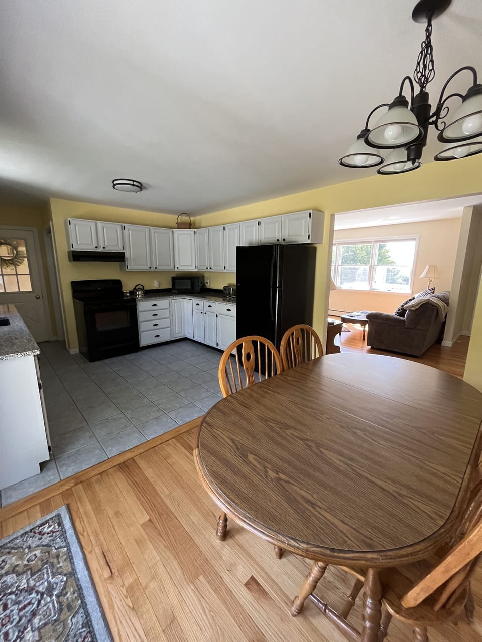View of dining area, kitchen and living room from back deck doorway. 