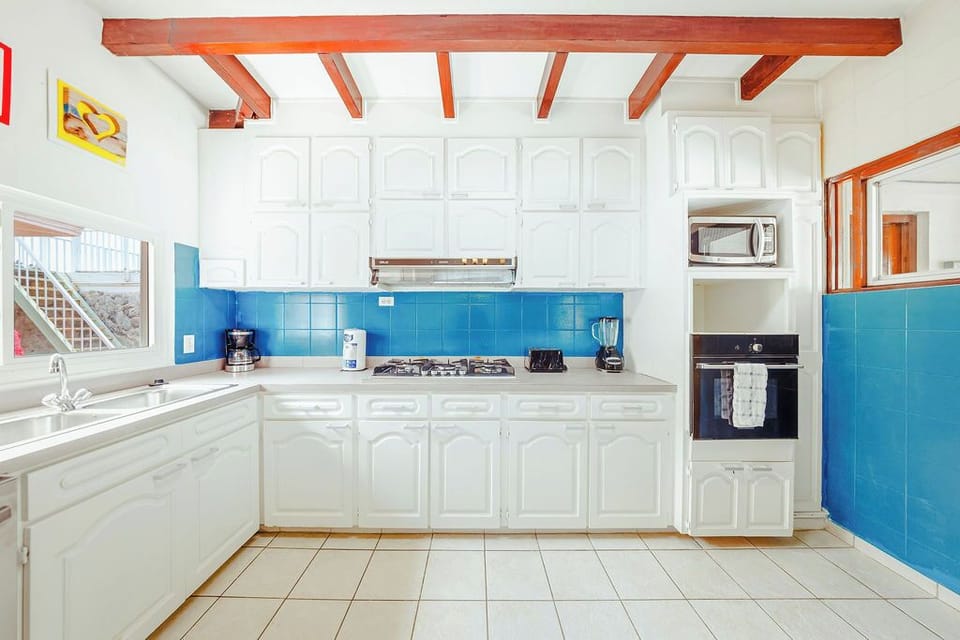 Our bright and fully equipped kitchen has everything you need to create fantastic vacation feasts. From morning coffee to a gourmet dinner, you'll find all the essentials here, set against a cheerful blue backsplash.