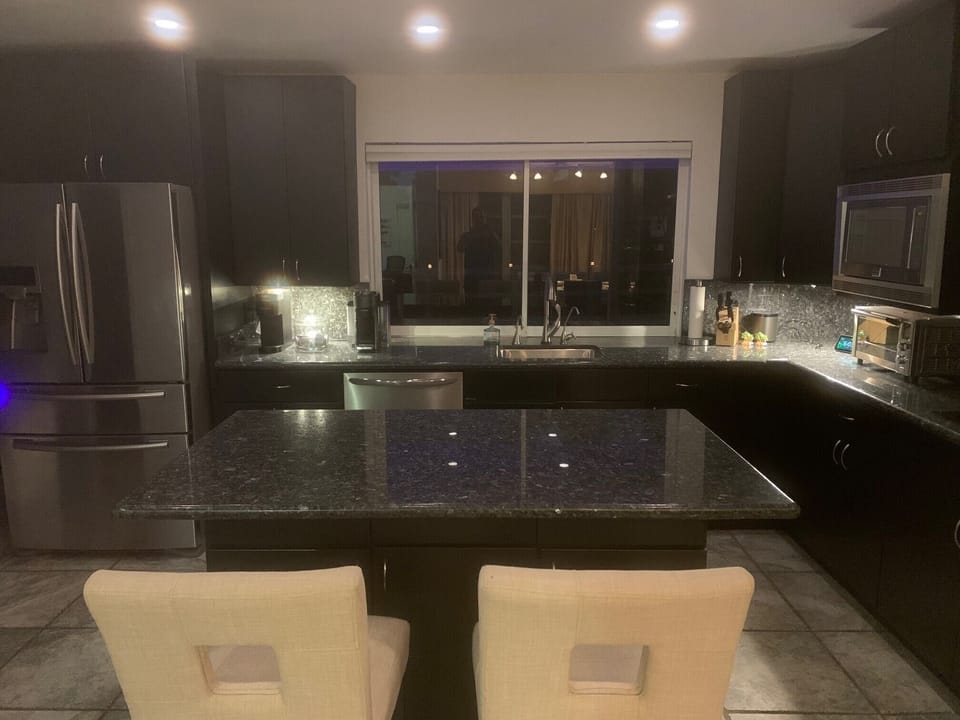 Kitchen features granite counters and under cabinet lighting.