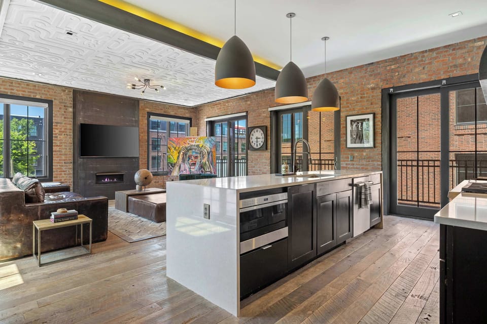 Spacious, fully equipped kitchen featuring a large island with bar seating, stainless steel appliances, coffee station, and plenty of counter space for preparing meals together.
